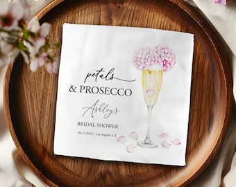 Könnte beinhalten: Weiße Papierserviette mit schwarzem Text, der "petals & PROSECCO Ashley's BRIDAL SHOWER 05.12.2025 | Los Angeles, CA" lautet. Eine Aquarell-Illustration einer Champagnerflöte mit rosa Blüten und rosa Blütenblättern.