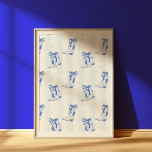 May include: A framed print featuring a repeating pattern of blue cowboy boots with bows and star accents on a cream and blue striped background. The boots are detailed with a classic design, creating a country-western theme.