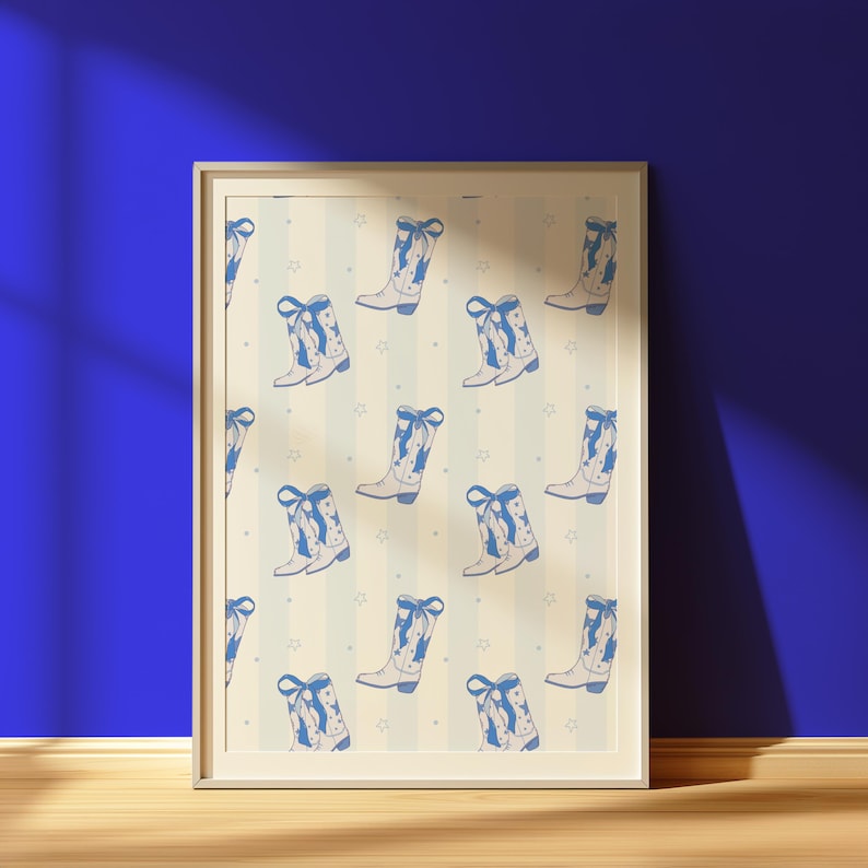 May include: A framed print featuring a repeating pattern of blue cowboy boots with bows and star accents on a cream and blue striped background. The boots are detailed with a classic design, creating a country-western theme.