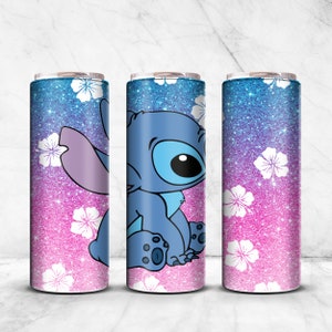 May include: Three stainless steel tumblers with a pink and blue glitter background and white flowers. The center tumbler features a blue cartoon character, Stitch, from the Disney movie Lilo & Stitch.
