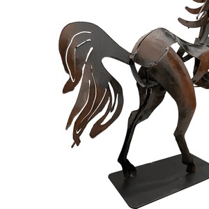 May include: A metal sculpture of a horse with a brown and black finish. The horse is standing on a black metal base.