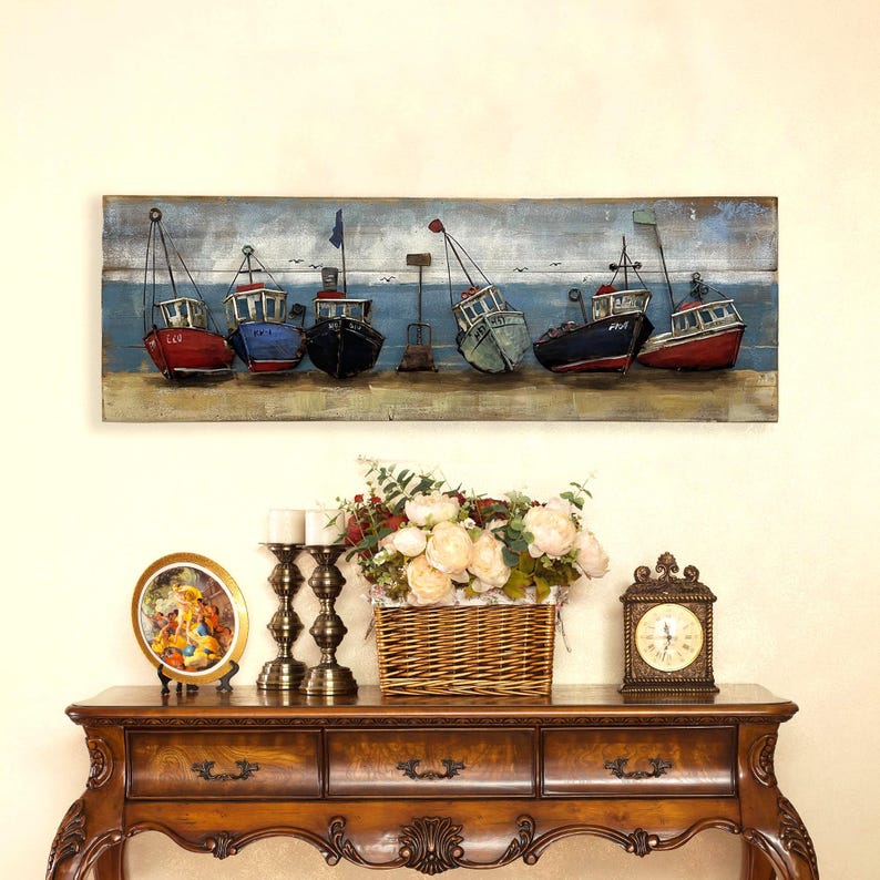 Peut inclure: Une longue &oelig;uvre d'art murale rectangulaire repr&eacute;sentant une rang&eacute;e de bateaux de p&ecirc;che stylis&eacute;s et color&eacute;s sur un fond en bois. Les bateaux sont peints dans des tons de rouge, bleu, vert et noir, avec des accents blancs. L'arri&egrave;re-plan est bleu clair et gris, avec un soup&ccedil;on de nuages blancs. Les bateaux sont dispos&eacute;s en rang&eacute;e, la proue de chaque bateau &eacute;tant tourn&eacute;e vers le spectateur. L'&oelig;uvre d'art est parfaite pour ajouter une touche nautique &agrave; n'importe quelle pi&egrave;ce.