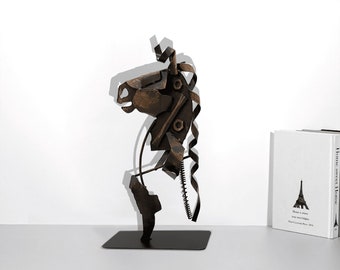 May include: Abstract metal sculpture of a horse's head, made from recycled materials. The sculpture is brown and black and has a rustic, industrial look.