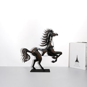 May include: A black metal horse sculpture with a raised tail and mane. The horse is standing on a black base.