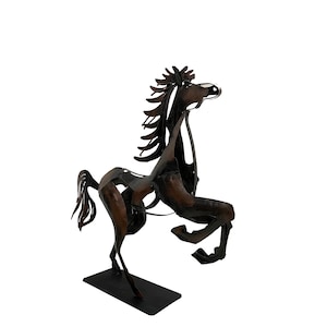 May include: A black metal sculpture of a horse standing on its hind legs. The horse is made of various pieces of metal that have been welded together to create a unique and abstract design.