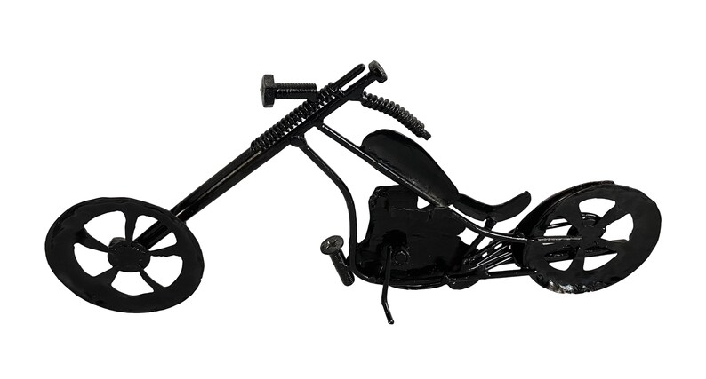 May include: A black metal motorcycle sculpture with a detailed design. The motorcycle has a long, curved frame and two wheels with a spoke design. The sculpture is made of recycled metal and is a unique and interesting piece of art.