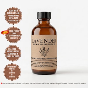 May include: A 4 oz. amber glass bottle of lavender reed diffuser refill oil with a black cap and a tan label featuring a lavender illustration and text including Made with 100% pure essential oil and handcrafted by Nishac.