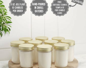 May include: Ten 8 oz jelly jar candles with gold lids are arranged on a wooden tray. The candles are hand-poured in small batches. The image includes text that says "Free Editable Canva Template for Candle Label".