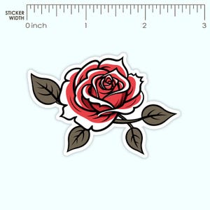 Op de afbeelding: Een sticker met een rode roos met witte accenten en een zwarte omtrek. De roos is omgeven door bruine bladeren en stelen. De sticker is ongeveer 5 cm breed.