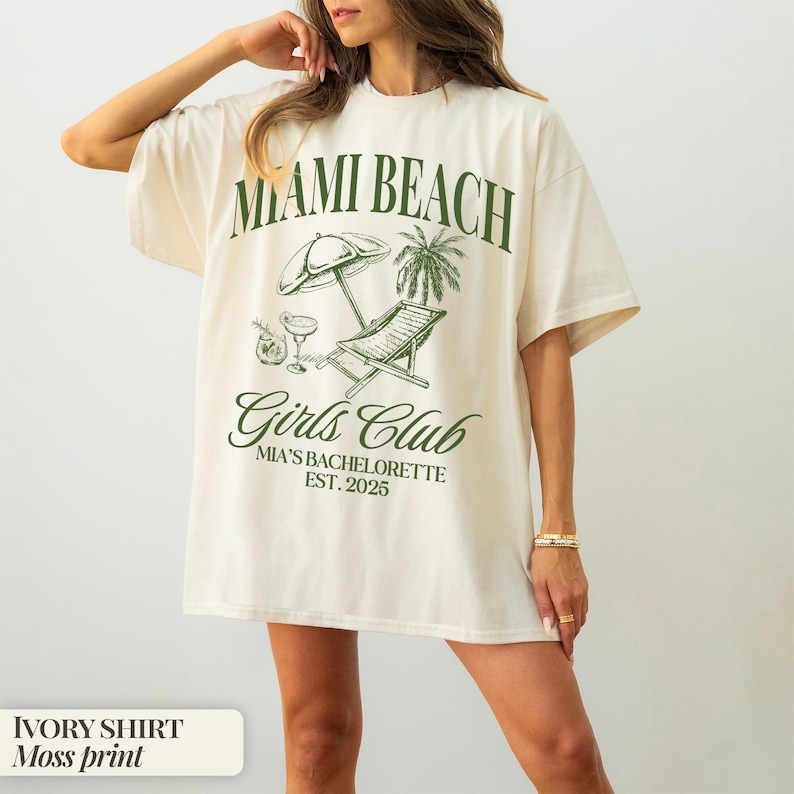 May include: Ivory shirt with a green graphic print that says "Miami Beach Girls Club Mia's Bachelorette Est. 2025".