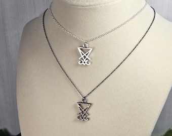 May include: Two silver necklaces with a silver pendant featuring the sigil of Baphomet. The necklaces are on a white mannequin bust. One necklace has a black chain and the other has a silver chain.
