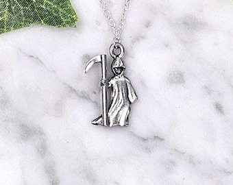 May include: A silver necklace with a pendant of the Grim Reaper holding a scythe.