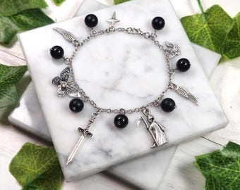 May include: A silver charm bracelet with black beads and various charms, including a sword, a butterfly, a reaper, and wings.