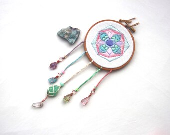 Atrapasueños bordado con mandala en tonos pastel, con gotas de cuarzo aura y cristal.