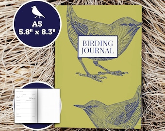 Könnte beinhalten: Ein grünes Journal mit dem Text "Birding Journal" auf dem Cover. Das Cover zeigt zwei blaue Illustrationen von Vögeln. Das Journal hat das Format A5, das sind 14,7 cm mal 21 cm.