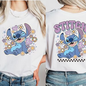 a woman wearing a white shirt with stitch on it