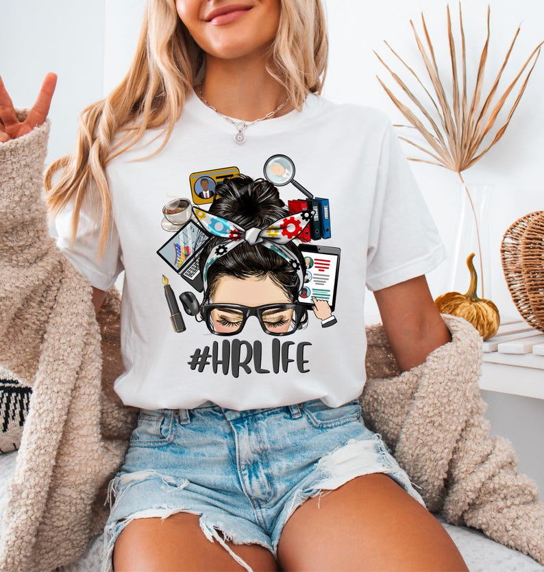 a woman sitting on a bed wearing a t - shirt with a picture of a