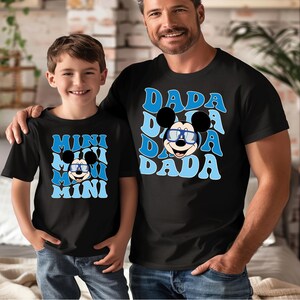 a man and a boy wearing mickey mouse shirts