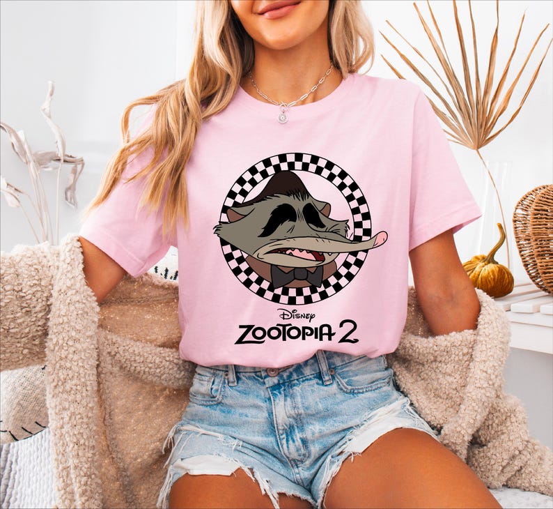 A woman wearing a pink t-shirt with a cartoon character and the text "Disney Zooopia 2" printed on it.