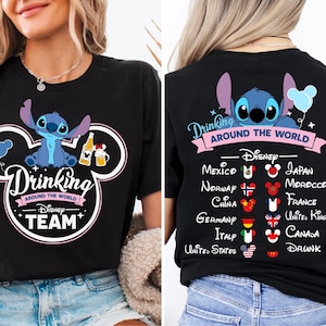 Op de afbeelding: Zwart T-shirt met een blauw Stitch-personage uit Lilo & Stitch. Het shirt heeft de tekst "Drinking Around the World - Disney Team" en een Mickey Mouse-oorontwerp. De achterkant van het shirt heeft een lijst met landen met vlaggen en de tekst "Drinking Around the World - Disney - Mexico, Noorwegen, China, Duitsland, Italië, Verenigde Staten, Japan, Marokko, Frankrijk, Verenigd Koninkrijk, Canada, Dronken."