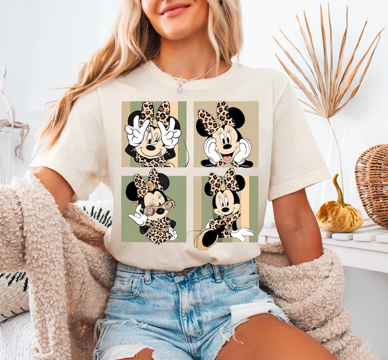 a woman sitting on a bed wearing a mickey mouse t - shirt
