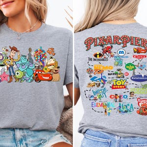 a woman wearing a gray shirt with cartoon characters on it