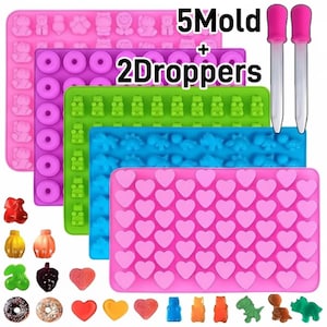 May include: Five rectangular silicone moulds in pink, purple, green, blue, and light pink, featuring cavities shaped like bears, donuts, hearts, and dinosaurs. Two clear plastic droppers with pink bulbs are included. Text reads 5Mold + 2Droppers.