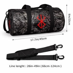 May include: Black and grey duffel bag with a red symbol. The bag is 45cm long, 23cm high, and has a detachable shoulder strap that adjusts from 66cm to 124cm. The bag features a graphic design.