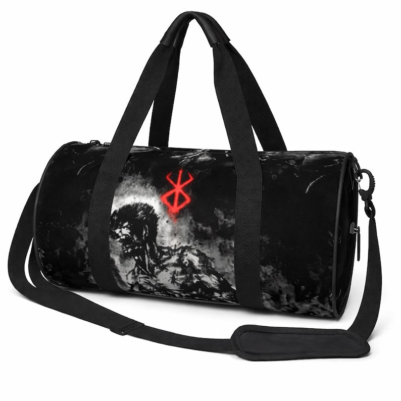 May include: Black duffel bag with a grayscale illustration of a muscular figure and a red symbol. The bag has black handles and a shoulder strap. The cylindrical bag is designed for carrying items.