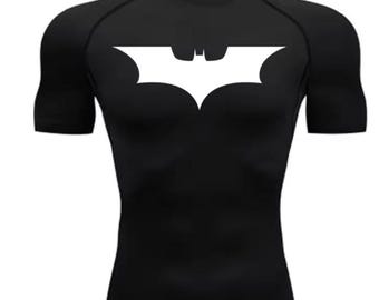 May include: Black compression top with a white Batman logo on the chest. The short-sleeved top is designed for a close fit and is made of a stretchy material. The Batman logo is a stylized bat symbol.
