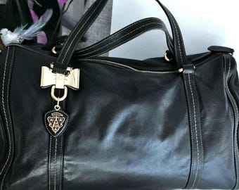 Bolso Gucci, estilo años 90, piel lisa negra, lujo vintage, fabricado en Italia, con herrajes dorados y el distintivo charm de Gucci, para mujer.