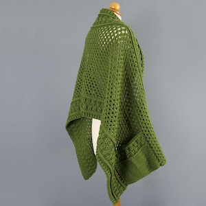 May include: A green crochet shawl with a lacy pattern and a pocket on the side.
