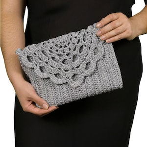 May include: A silver crocheted clutch bag with a lacy design.