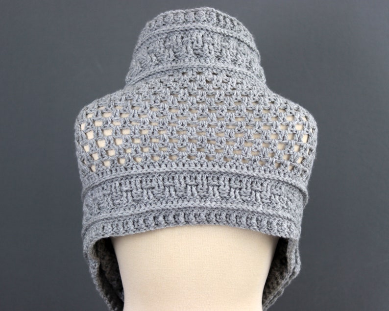 May include: Gray crocheted cowl with a geometric pattern. The cowl is made with a lightweight yarn and has a loose, open weave.