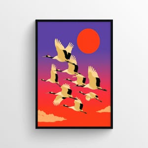 Könnte beinhalten: Ein gerahmter Kunstdruck mit einer Schar weißer Kraniche mit schwarzen Flügelspitzen, die vor einem Farbverlaufshimmel von tiefem Violett bis leuchtendem Orange fliegen, ergänzt durch eine große rote Sonne und helle Wolken am unteren Rand.