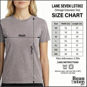 May include: A gray vintage crewneck tee shirt with a size chart. The size chart shows the width and length in inches for sizes XS to 3XL. Care instructions indicate machine wash cold and tumble dry low.