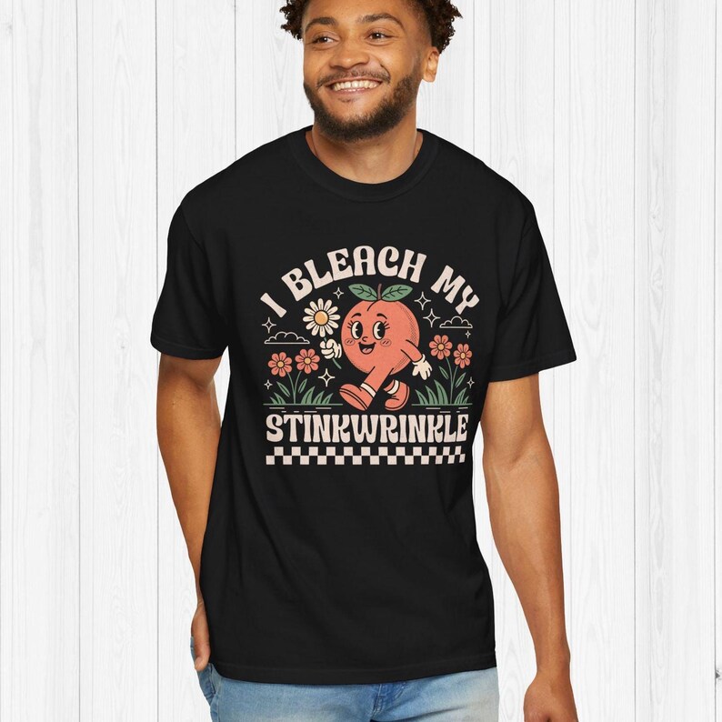 May include: Black t-shirt with a peach graphic and the text "I bleach my stinkwrinkle".
