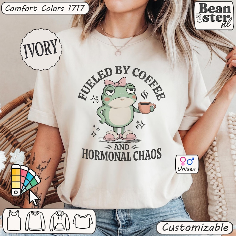 Pu&ograve; includere: T-shirt unisex color avorio con la scritta "FUELED BY COFFEE AND HORMONAL CHAOS" e un ranocchio dei cartoni animati con una tazza di caff&egrave;. La maglietta &egrave; di Comfort Colors ed &egrave; personalizzabile.