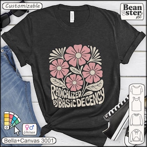 Op de afbeelding: Donkergrijs unisex T-shirt met een bloemenontwerp in roze en crème. De afbeelding toont gestileerde bloemen en de tekst "RADICALIZED BY BASIC DECENCY". Het shirt is een Bella+Canvas 3001.