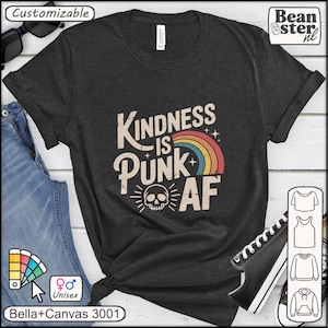 May include: Dark gray unisex t-shirt with the text "Kindness is Punk AF" in a distressed font, featuring a rainbow and skull graphic. The shirt is a Bella+Canvas 3001 model.