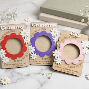 May include: Three wooden Mother's Day gifts with flower-shaped frames in red, purple, and pink. Each frame has a name: "Grammy", "Grandma", and "Gigi". White daisies and text saying "If you were a flower, we would pick you" are included.