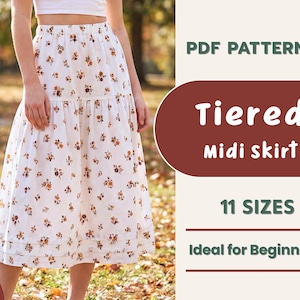 May include: A white tiered midi skirt with a floral design. The skirt features a ruffled hem and is displayed on a person. The image also includes text that says "PDF Pattern", "Tiered Midi skirt", and "11 Sizes".
