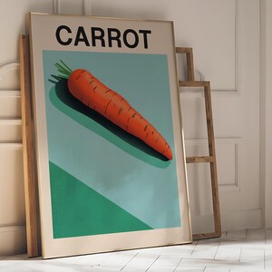 May include: A framed poster with the word "CARROT" in black text on a light blue background. A single orange carrot is depicted on the poster, with green leafy tops.