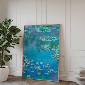 May include: A framed painting of a blue pond with water lilies. The water lilies are white and green and the water is a light blue color. The painting is in a light wood frame.