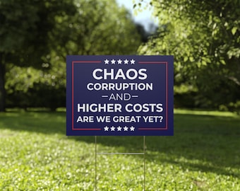 May include: A rectangular yard sign with a dark blue background and a thin red border. The text reads: CHAOS CORRUPTION AND HIGHER COSTS ARE WE GREAT YET? Five white stars are positioned in a horizontal row above and below the text.