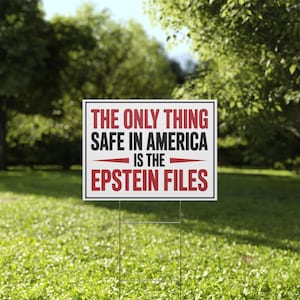 May include: A white rectangular yard sign with black and red text that reads: "THE ONLY THING SAFE IN AMERICA IS THE EPSTEIN FILES." The sign is placed in a grassy yard with trees in the background.