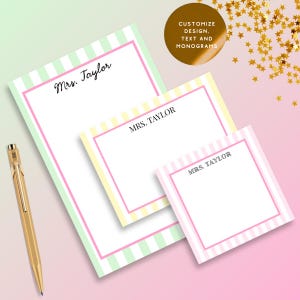 May include: Three rectangular stationery sheets of varying sizes with light green, yellow, and pink vertical stripes and a pink border. Each sheet features the printed text Mrs. Taylor in black ink. A gold-toned metal pen is positioned to the left.