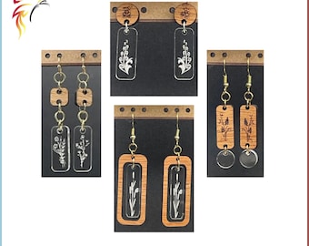 Puede incluir: Cuatro pares de pendientes de madera cortados con láser con diseños florales. Los pendientes se muestran sobre un fondo marrón con agujeros.