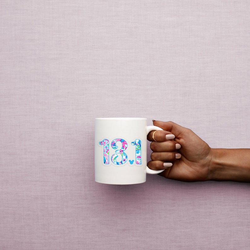 Puede incluir: Taza de cer&aacute;mica blanca con un dise&ntilde;o colorido de los n&uacute;meros "18.1" y un peque&ntilde;o icono de Mickey Mouse.