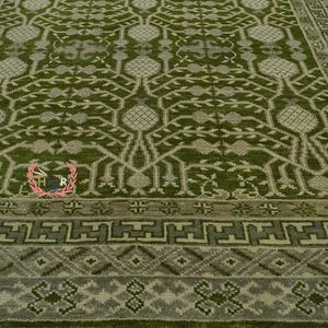 May include: A green and cream patterned rug with a geometric design. The rug has a fringe border.